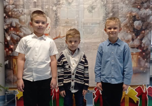Damina, Julek i Bartek pozują do zdjęcia na tle zimowej fotościanki