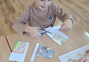 Wiktor wycina pokolorowane puzzle.