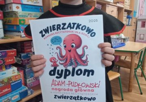 Adaś z dumą prezentuje dyplom z konkursu