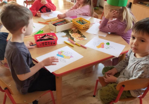 Dzieci wykonują przy stolikach pracę związaną tematycznie z różą.