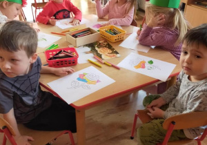 Dzieci wykonują przy stolikach pracę związaną tematycznie z różą.
