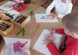 Dzieci wykonują przy stolikach pracę związaną tematycznie z różą.