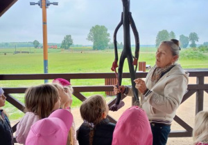 Dzieci stoją i patrzą na panią z rzeźbą w ręku