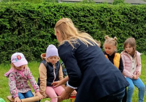 Pani i dzieci przyglądają się dziewczynce z wałkiem