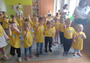 Dzieci z podniesionymi paluszkami składają uroczyste ślubowanie