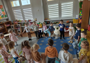 Dzieci tańczą ze swoimi misiami w kole