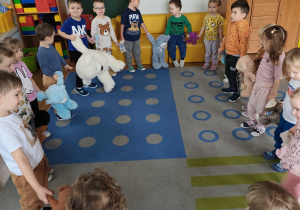 Dzieci tańczą ze swoimi misiami w kole