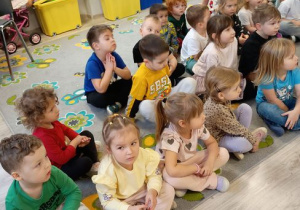 Dzieci siedzą na dywanie