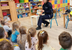 Policjantka otwiera książeczkę