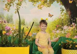 Dzieci pozują do zdjęcia na tle wiosennej łąki