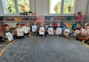 Chłopcy prezentują pokolorowane przez siebie kartę "Dzień Chłopaka"