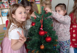 Dziewczynki wieszają bombki na choince