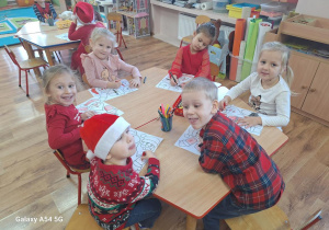 Dzieci wykonują pracę plastyczną z bohaterem dzisiejszego dnia - Św. Mikołajem.