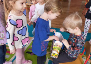 Tomek częstuje dzieci cukierkami.