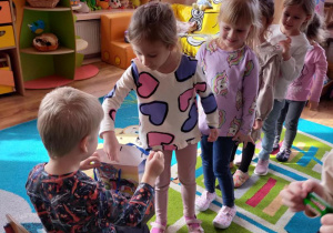 Dzieci składają Tomkowi życzenia i częstują się cukierkami urodzinowymi.