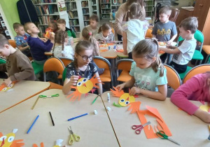Dzieci odrysowują swoje ręce, które mają pełnić funkcję skrzydeł kurczaka