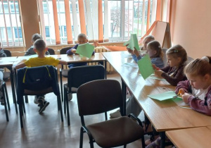 Dzieci wycinają paski z zielonego papieru