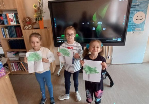 Emilka, Hania, Lada prezentują wykonane przez siebie drzewa