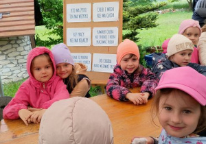 Dzieci siedzą przy stole i pozują do zdjęcia