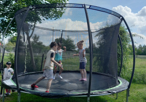 Dzieci skaczą na trampolinie