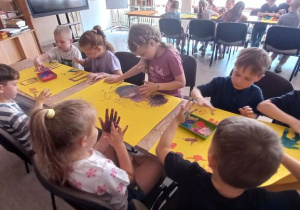 Dzieci stemplują palcami na brystolu