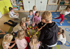 Dzieci układają serce z jabłka