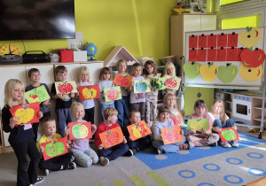 Dzieci prezentują prace plastyczne - jabłka wyklejone techniką wydzieranki