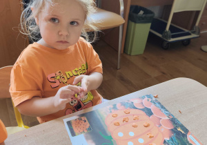 Michasia wykleja papierową dynię plasteliną