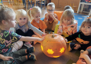 Dzieci pozują do zdjęcia ze swoim dyniowym lampionem