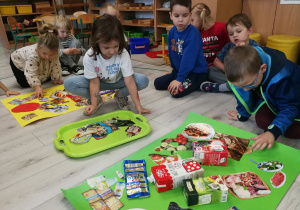 Montessoriaki wykonują plakaty o zdrowych produktach żywnościowych