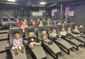 Dzieci siedzą w sali kinowej