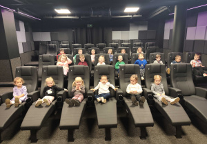 Dzieci siedzą w sali kinowej