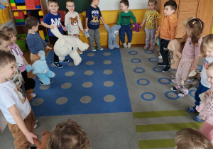 Dzieci tańczą ze swoimi misiami w kole