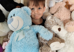 Oliwier pozuje do zdjęcia z misiami