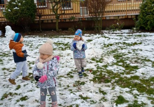 Troje dzieci patrzy na leżący śnieg
