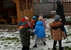 Dzieci wspólnie lepią bałwanka