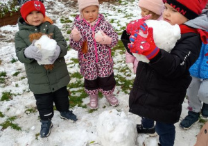 Dzieci trzymaja kule ze śniegu
