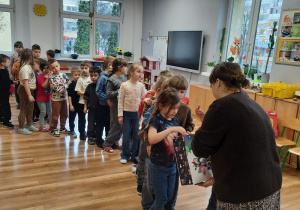 Dzieci częstują się cukierkami podarowanymi przez pana z Felkowego Stryszka