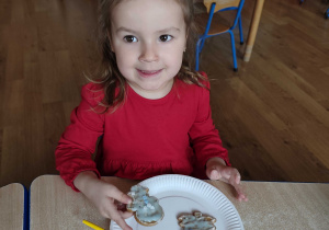 Justynka prezentuje udekorowane przez siebie pierniczki