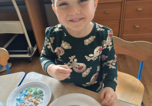 Kubuś prezentuje udekorowane przez siebie pierniczki