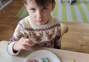 Oliwier prezentuje udekorowane przez siebie pierniczki