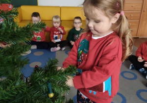 Dzieci wspólnie ubierają choinkę