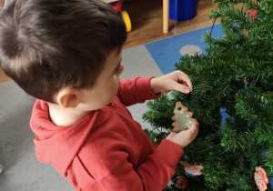 Dzieci wspólnie ubierają choinkę