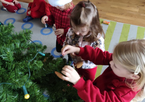 Dzieci wspólnie ubierają choinkę