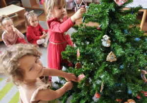Dzieci wspólnie ubierają choinkę