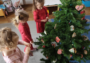 Dzieci wspólnie ubierają choinkę