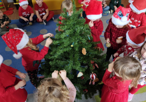 Dzieci wspólnie ubierają choinkę