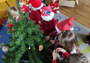 Dzieci wspólnie ubierają choinkę