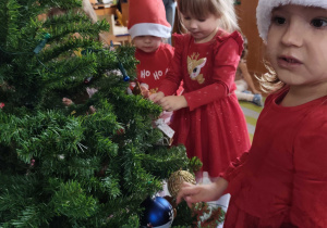 Dzieci wspólnie ubierają choinkę