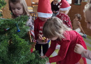 Dzieci wspólnie ubierają choinkę